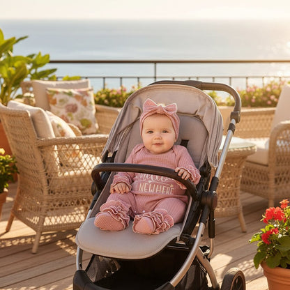 Bébé portant une barboteuse fille en poussette sur une terrasse de vacance | Choupinoo