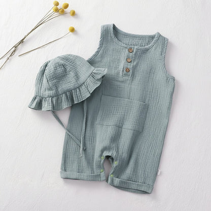 Combishort bébé été en mousseline bleu céladon avec chapeau bob à volants, flat lay minimaliste vue de dessus sur fond lin blanc – Choupinoo