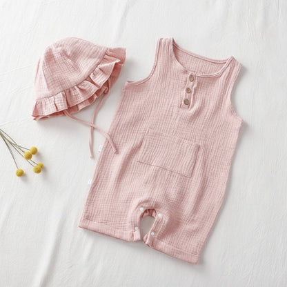 Combishort bébé été en mousseline rose avec chapeau bob à volants, flat lay minimaliste vue de dessus sur fond lin blanc – Choupinoo