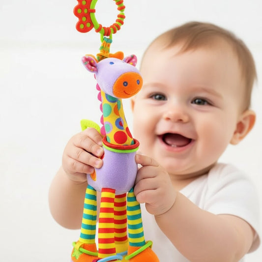 gros plan des mains de bébé qui touchent et explorent le doudou girafe, sourire à l'appui