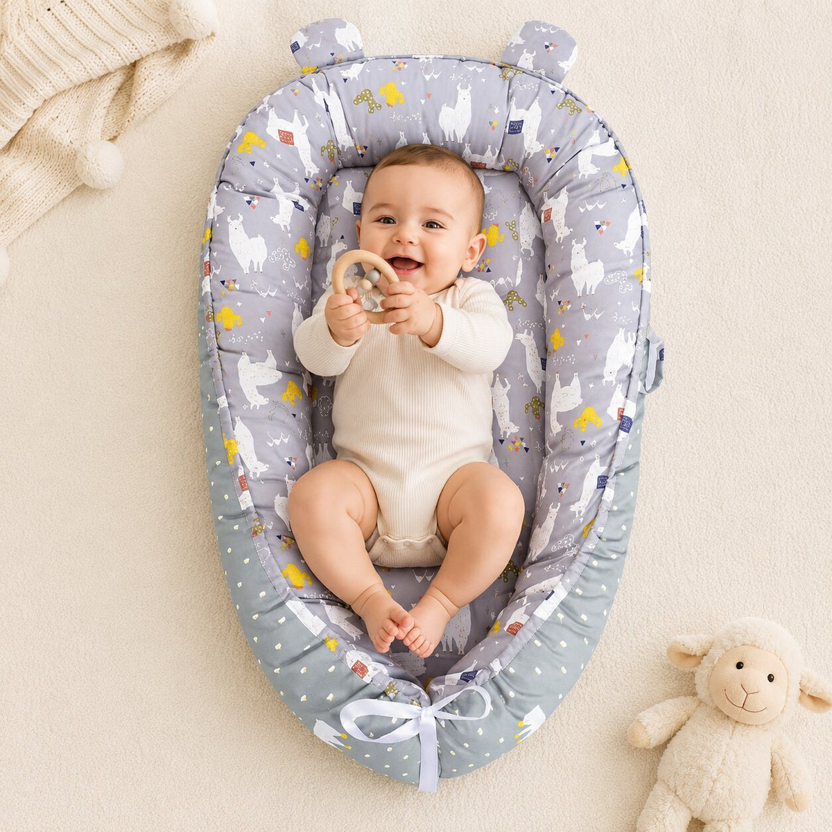 Bebe souriant dans nid d'ange reducteur motif lamas gris oreilles d'ours - Choupinoo