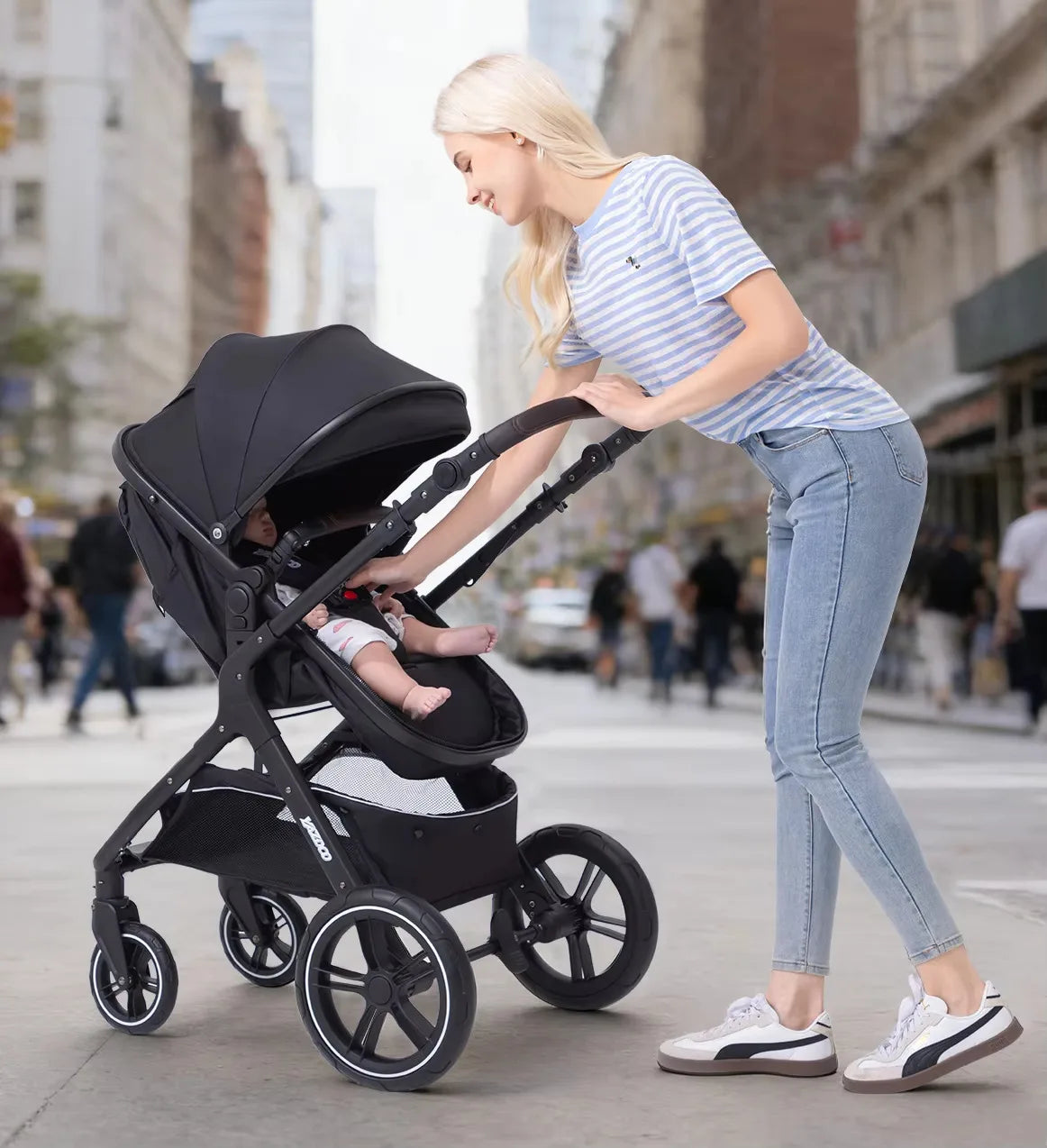 Maman promenant son bebe en poussette 3-en-1 noire en mode nacelle dans un parc ensoleille - Choupinoo
