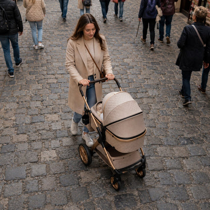 Maman vue de haut poussant une poussette 3 en 1 beige et or avec bébé dans la nacelle sur des pavés irréguliers, foule en arrière-plan - Choupinoo