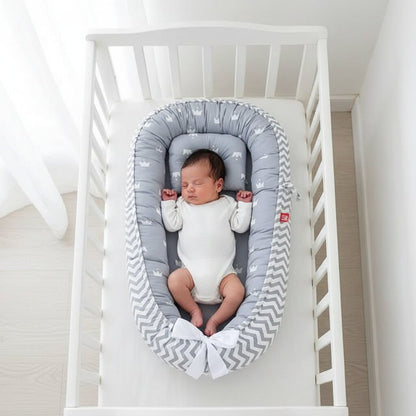 Reducteur de lit bebe cocon gris motif couronnes et chevrons avec nouveau-ne dans berceau - Choupinoo