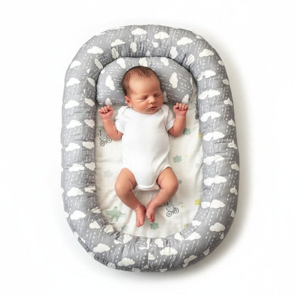 Reducteur de lit bebe gris motif nuages avec nouveau-ne endormi, vue de dessus - Choupinoo