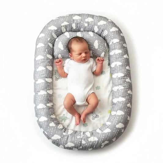 Reducteur de lit bebe gris motif nuages avec nouveau-ne endormi, vue de dessus - Choupinoo