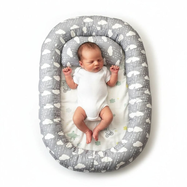 Reducteur de lit bebe gris motif nuages avec nouveau-ne endormi, vue de dessus - Choupinoo