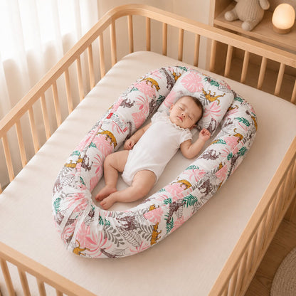 Reducteur de lit bebe cocon motif jungle rose et vert, bebe endormi dans un lit en bois - Choupinoo