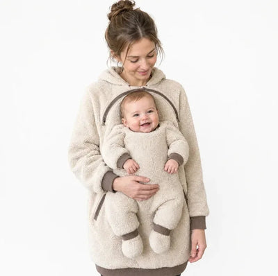 Maman portant son bébé contre elle dans un sweat à capuche de portage bébé 2 en 1 doublé polaire, avec poche ventrale enveloppante pour les sorties par temps frais.

 Copier